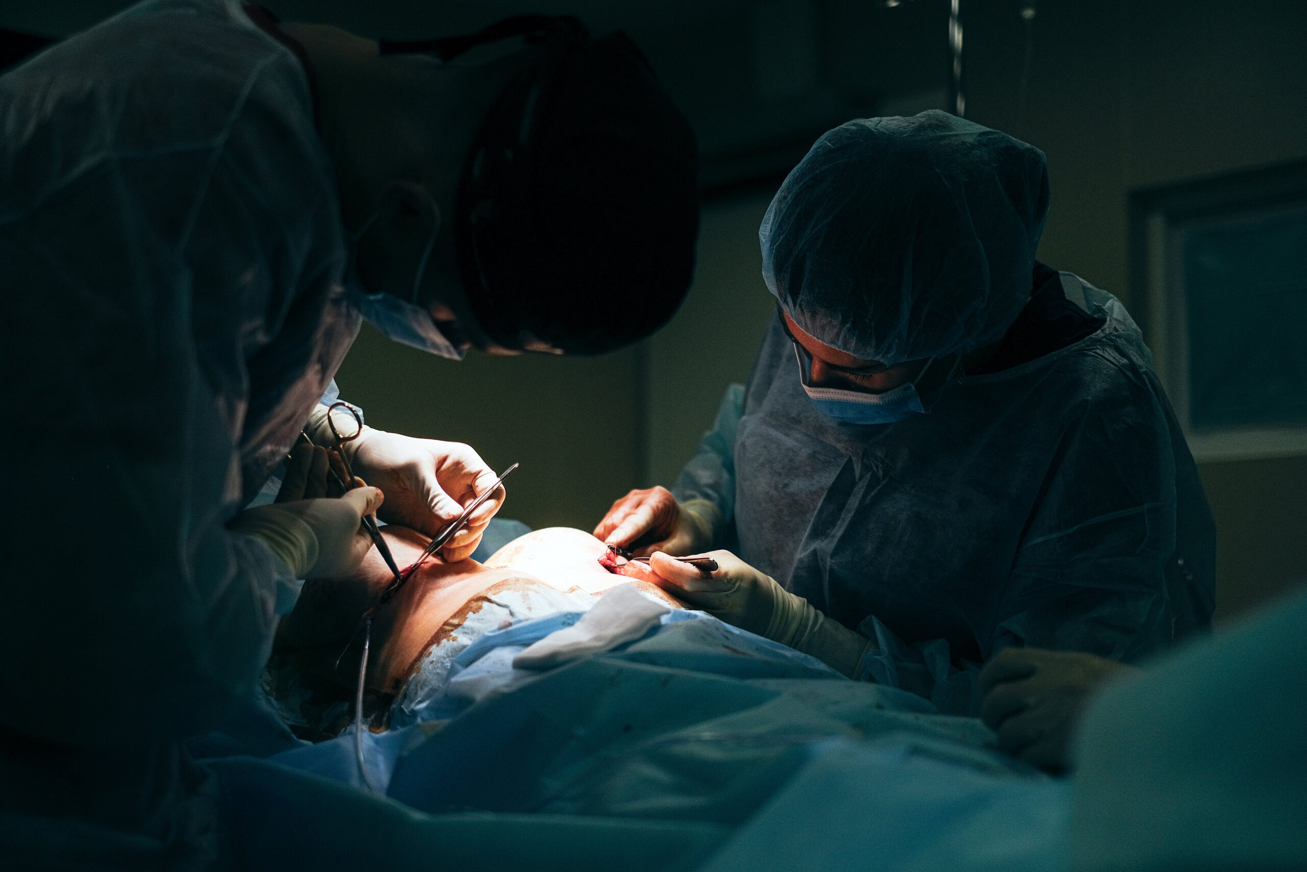 Surgeons are conducting breast augmentation surgery on a patient.