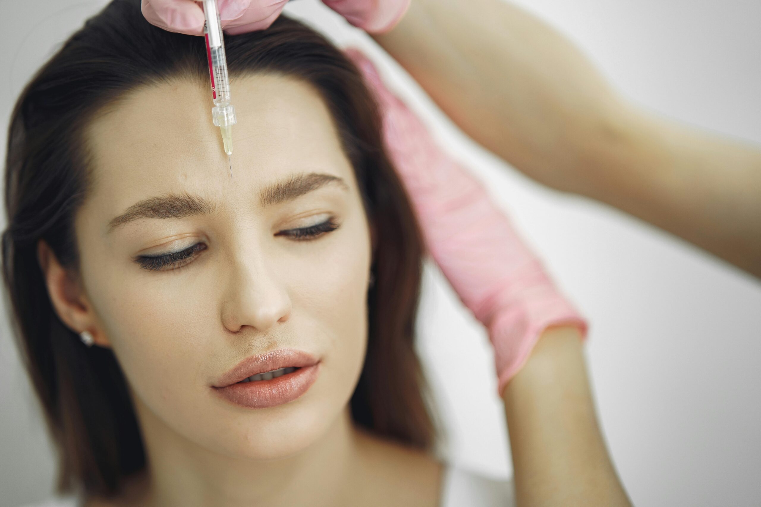 Woman receiving injection in her forehead